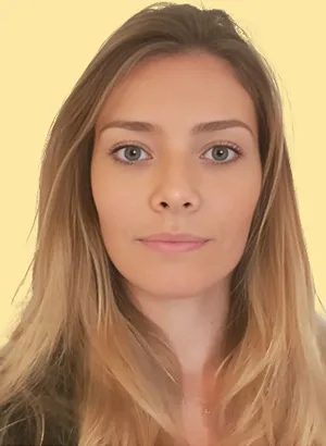 Femme aux cheveux blonds sur fond jaune, regard neutre.