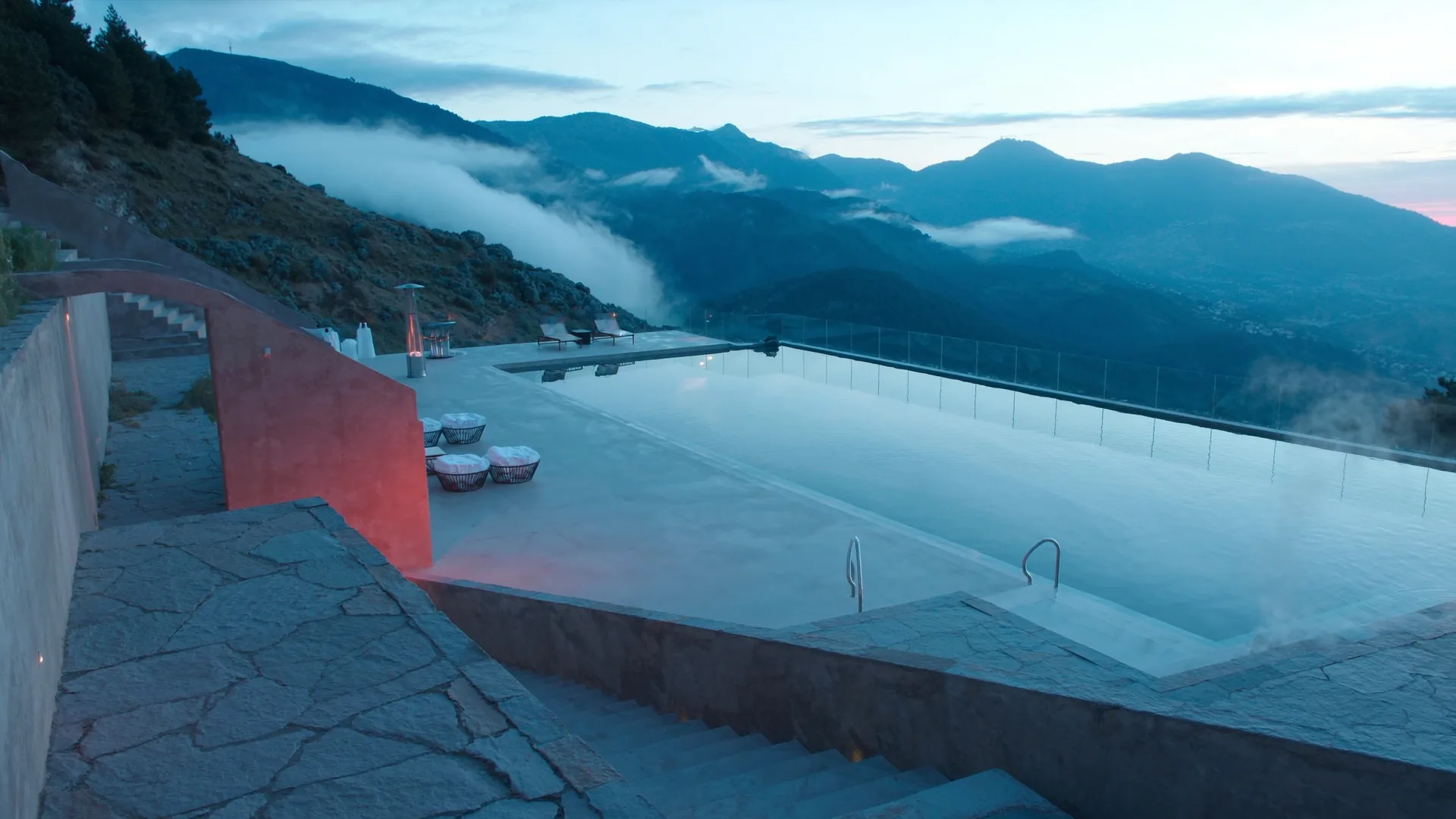 Thermal infinity pool at dawn with alpine mountain backdrop, representing wellness resort AI visibility measurement