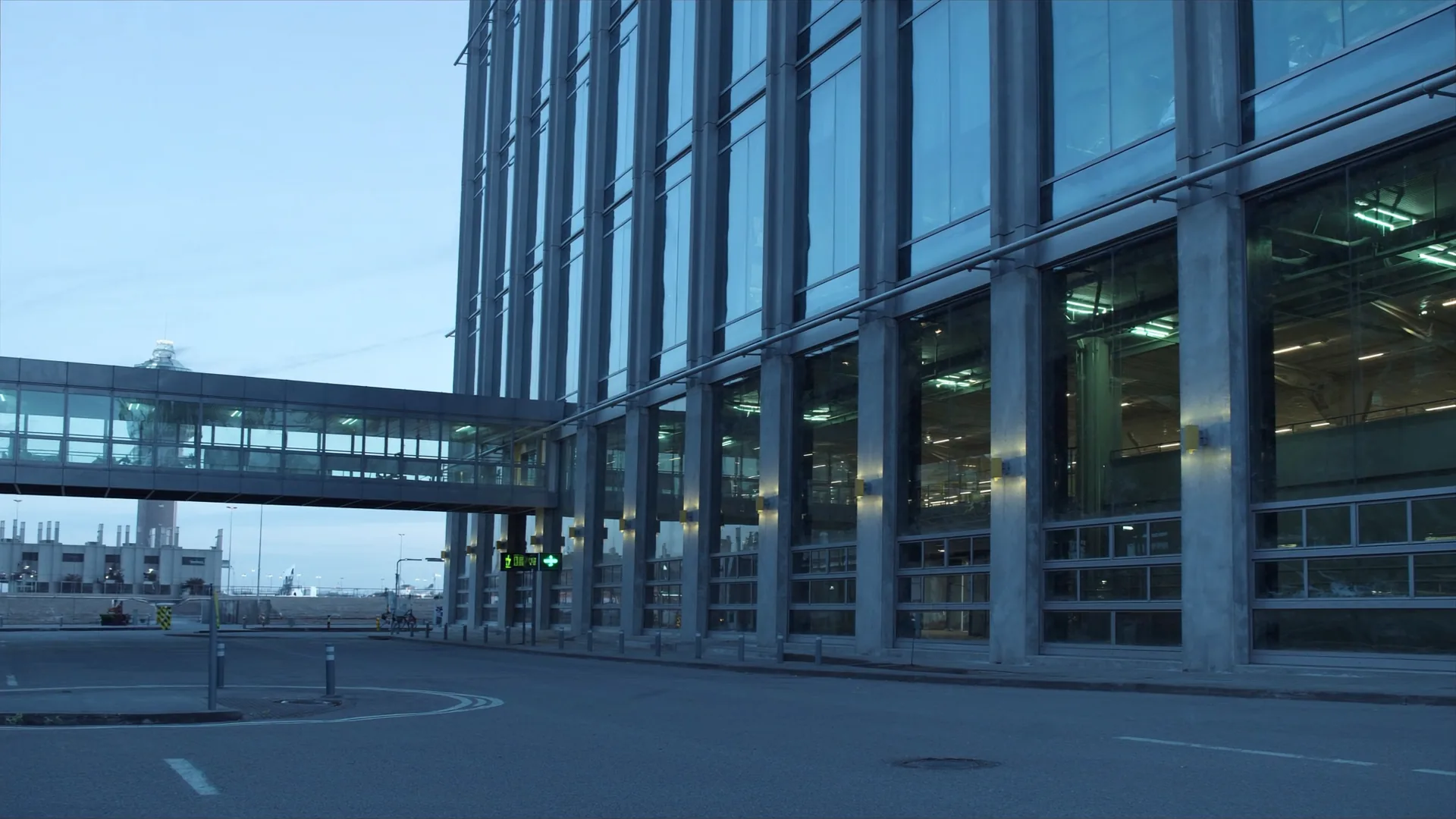 Airport hotel connected to terminal by covered walkway at dusk with runway lights, representing transit hotel AI visibility measurement