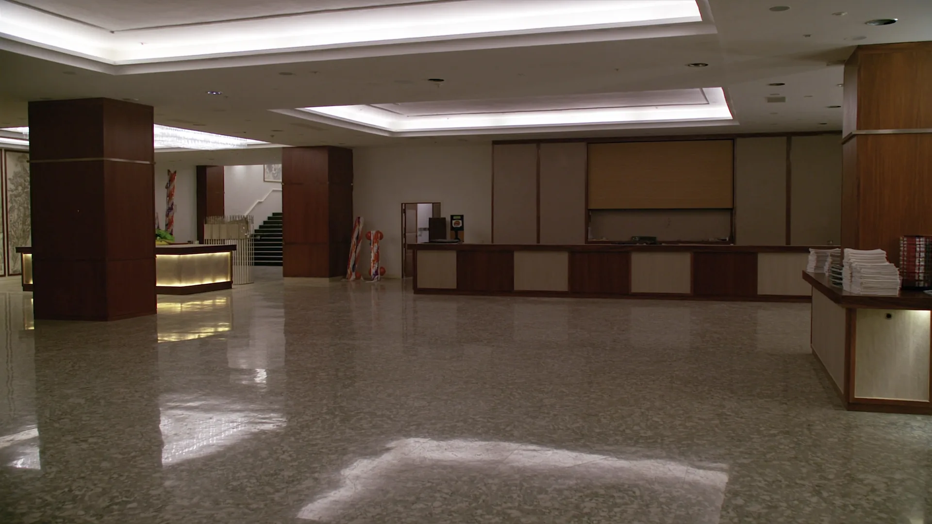 Newly renovated grand hotel lobby with polished terrazzo floor and fresh furnishings, photographed at twilight before reopening