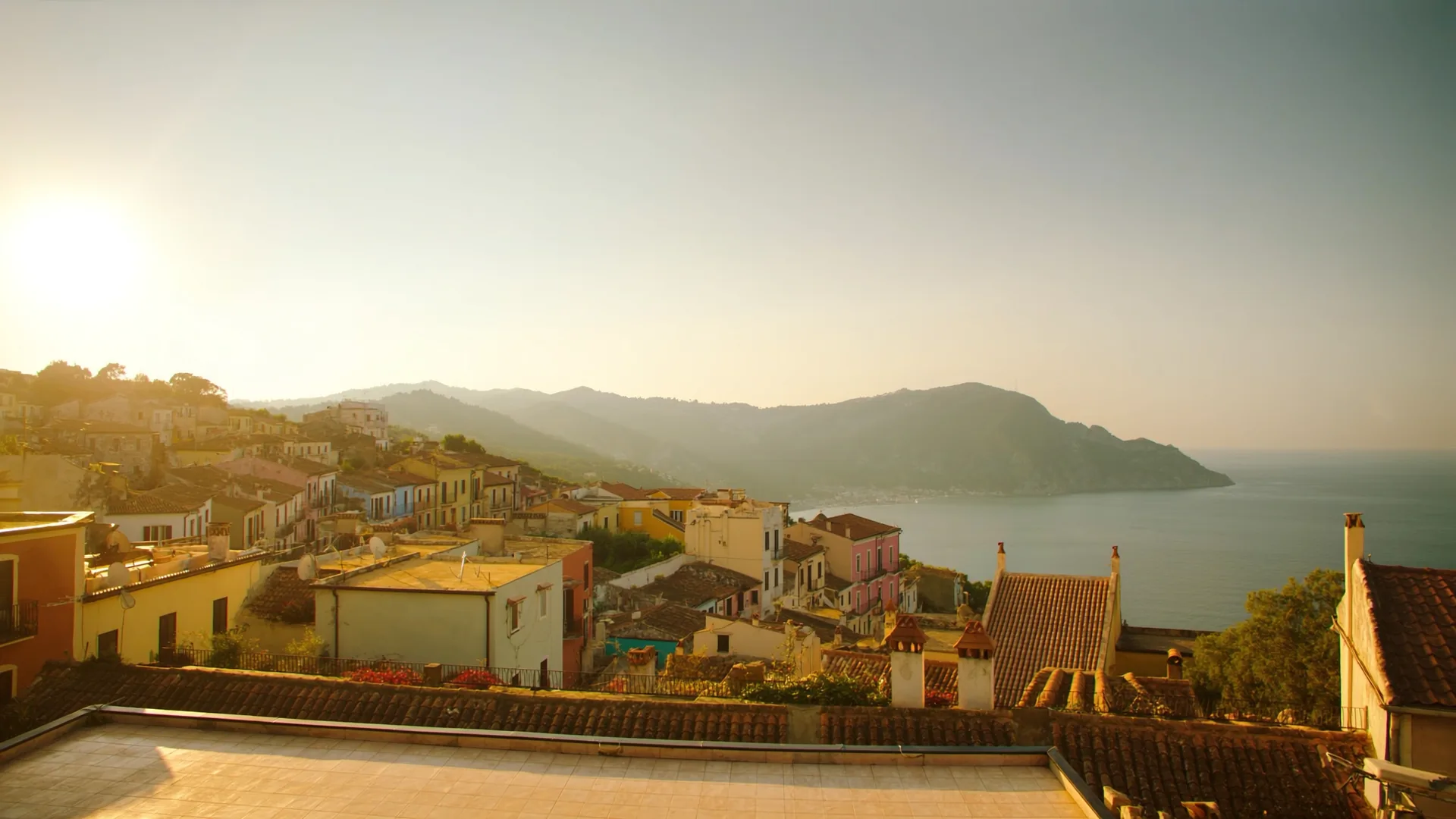 Mediterranean coastal village at golden hour representing the competitive AI visibility landscape for European hospitality properties